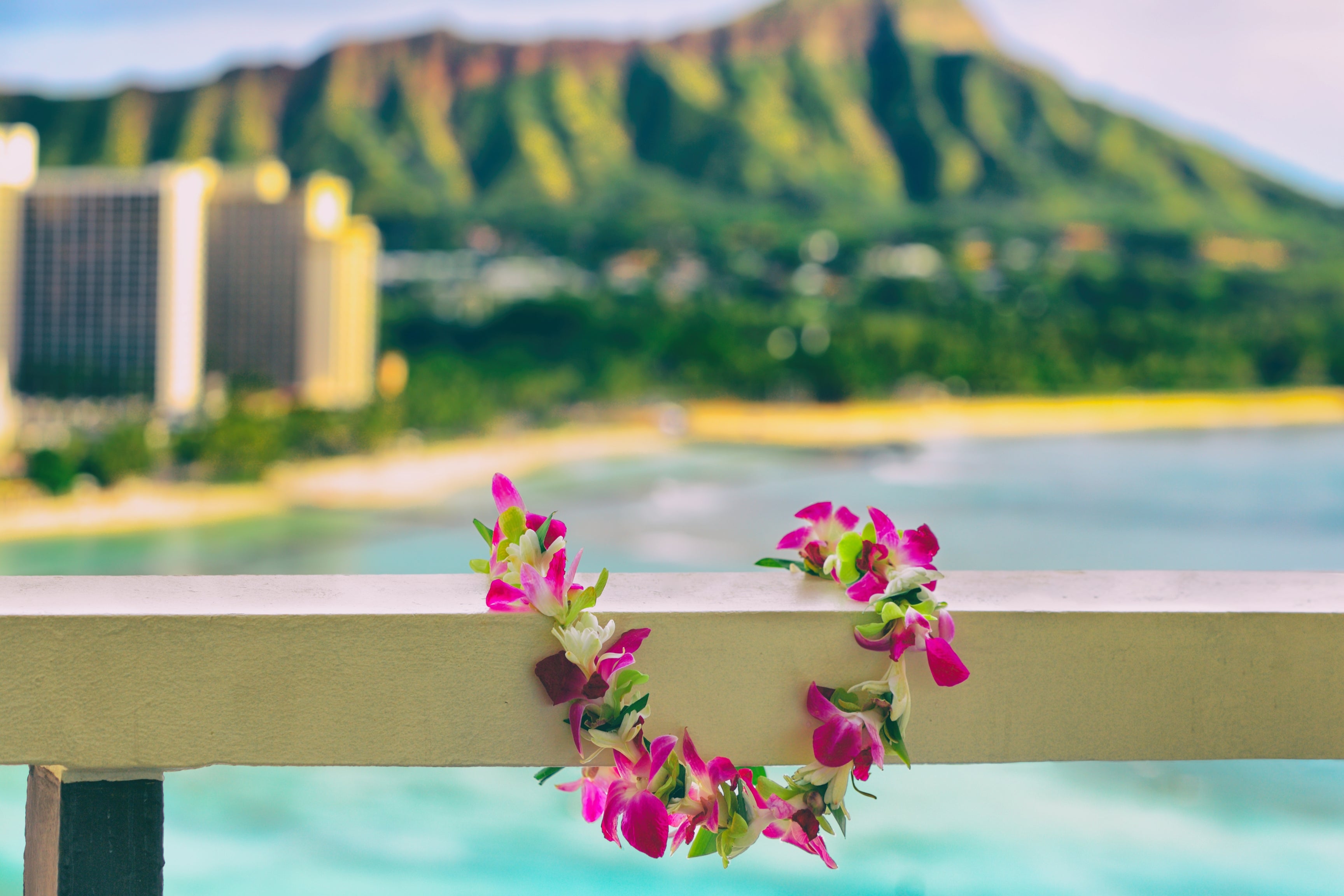 lei on balcony rail green mountain backround