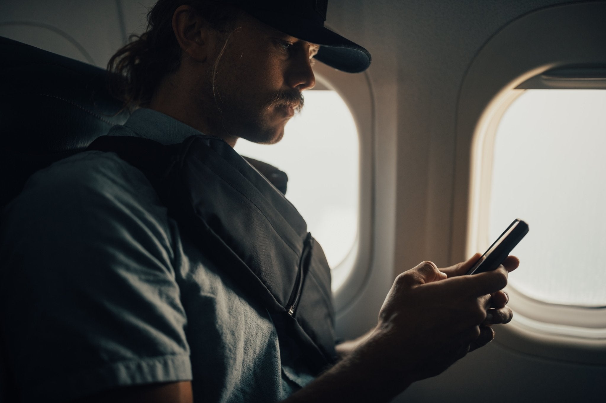 2L Sling Belt (42L Backpack Waist Belt/Sling Bag) - Gravel - Man wearing 2 Liter sling bag across chest on an airplane