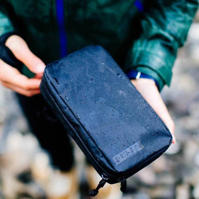 Garage Sale | V1 Explorer SLIM™ Toiletry Bag - Traveling Lighter - Gravel - Man holding wet Explorer SLIM™ Toiletry Bag