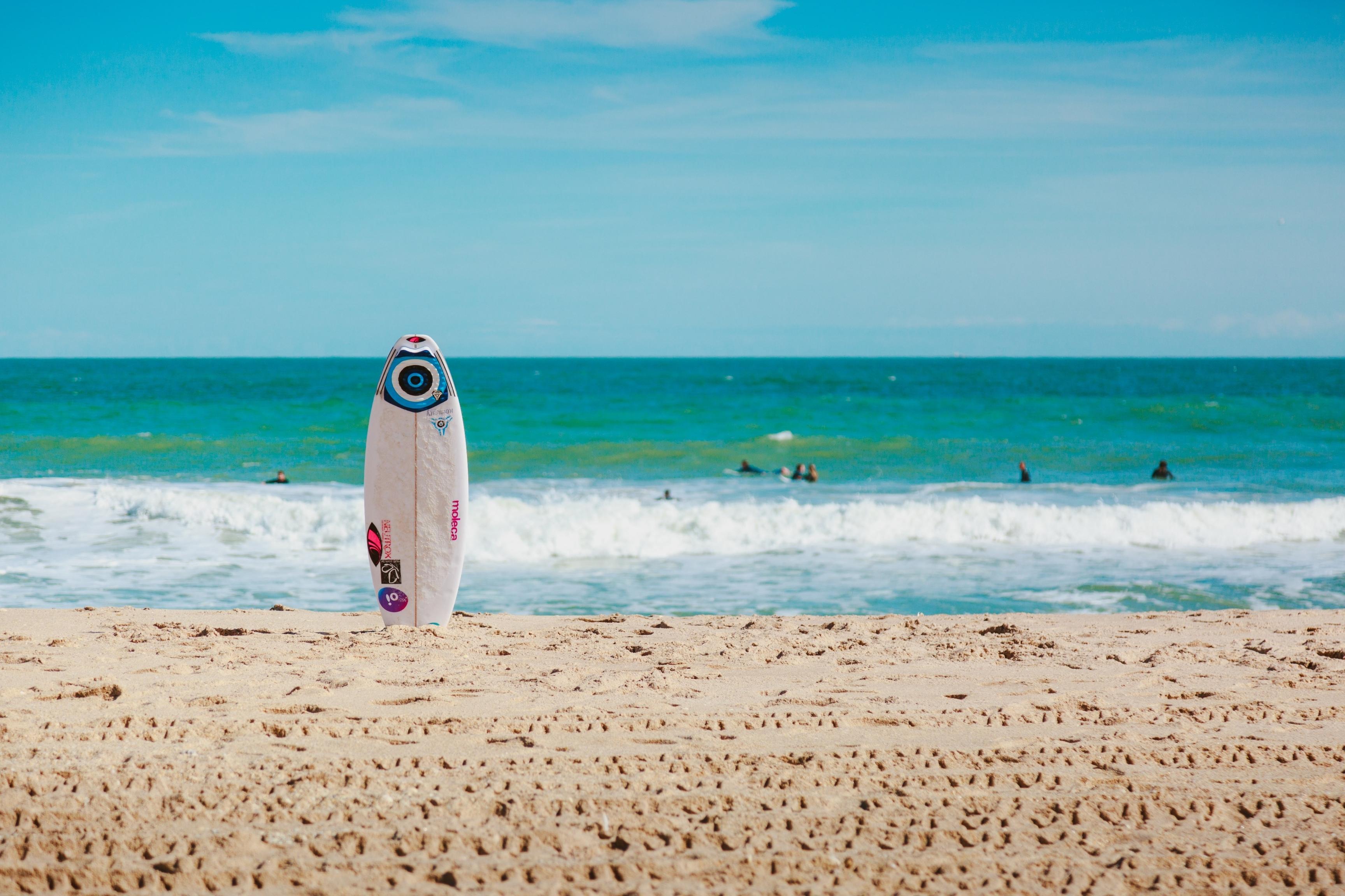 packing list for beach vacation surfboard in sand
