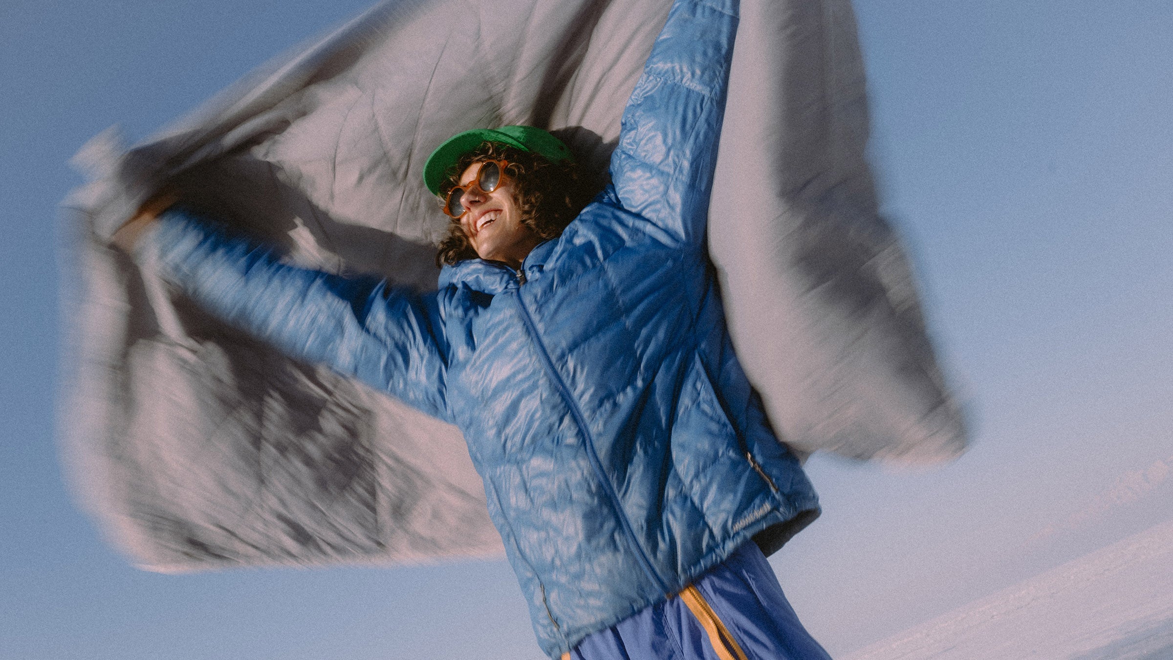 Person in blue winter clothing with a blanket against a snowy background