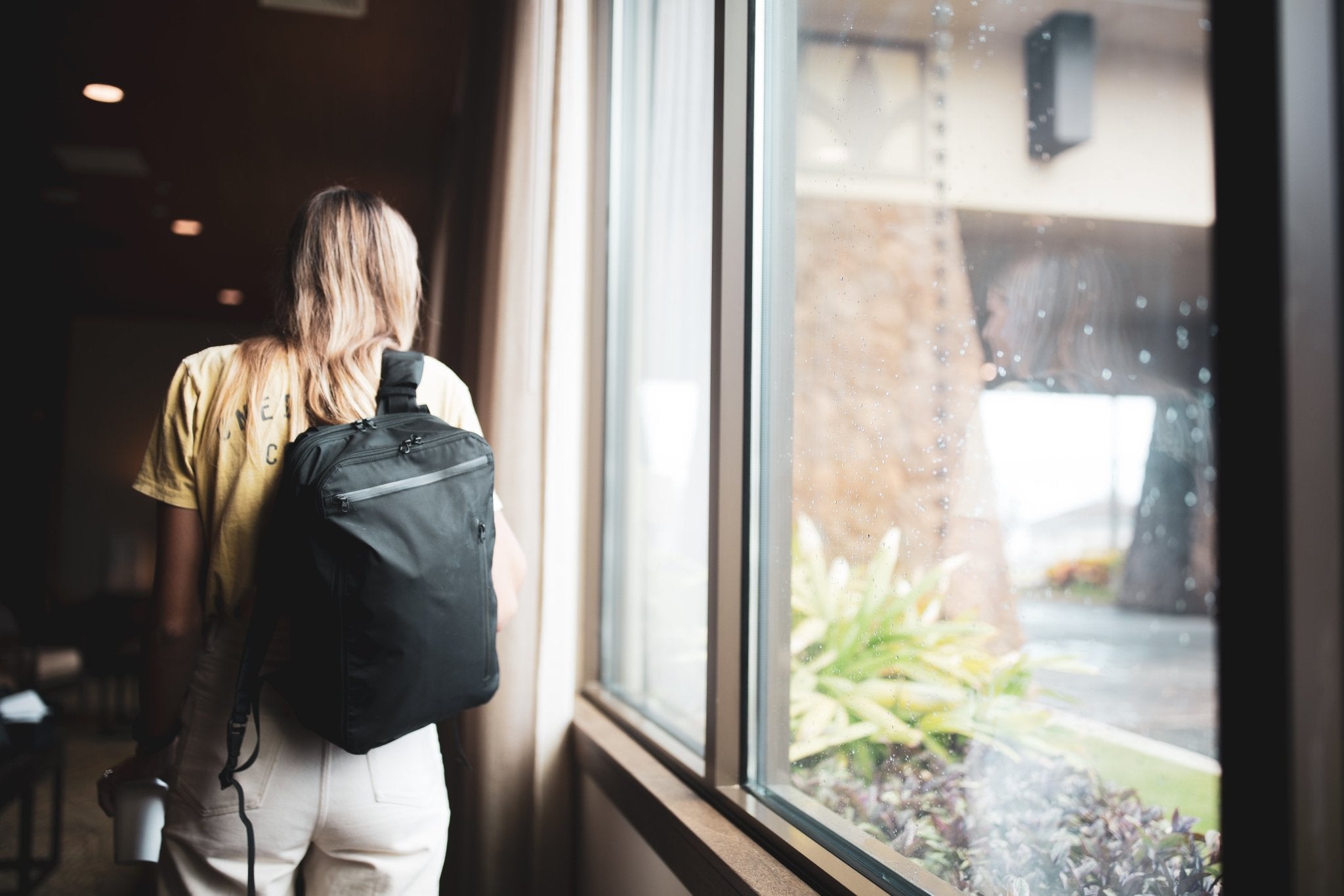 11L Day Bag - Gravel - Woman with 11 Liter backpack carrying a coffee cup
