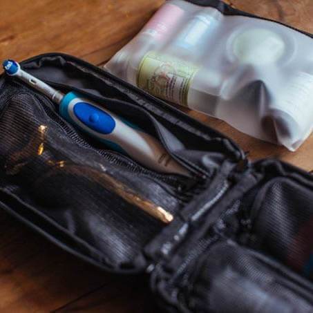 Toiletry Bag For Men - The Explorer PLUS open on a table next to its TSA Compliant Bag